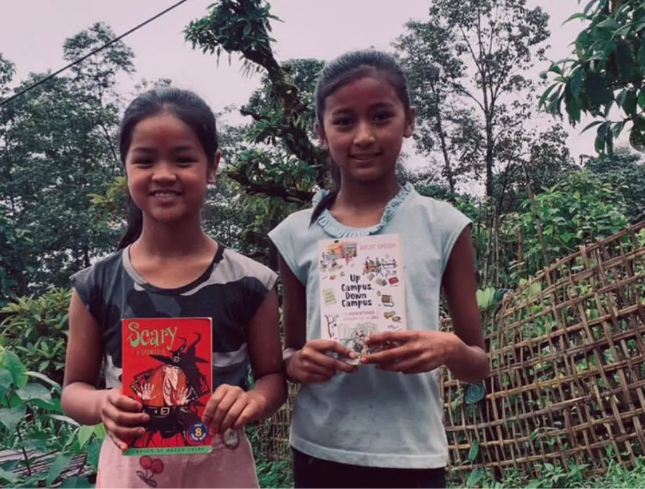 Two girls holding books